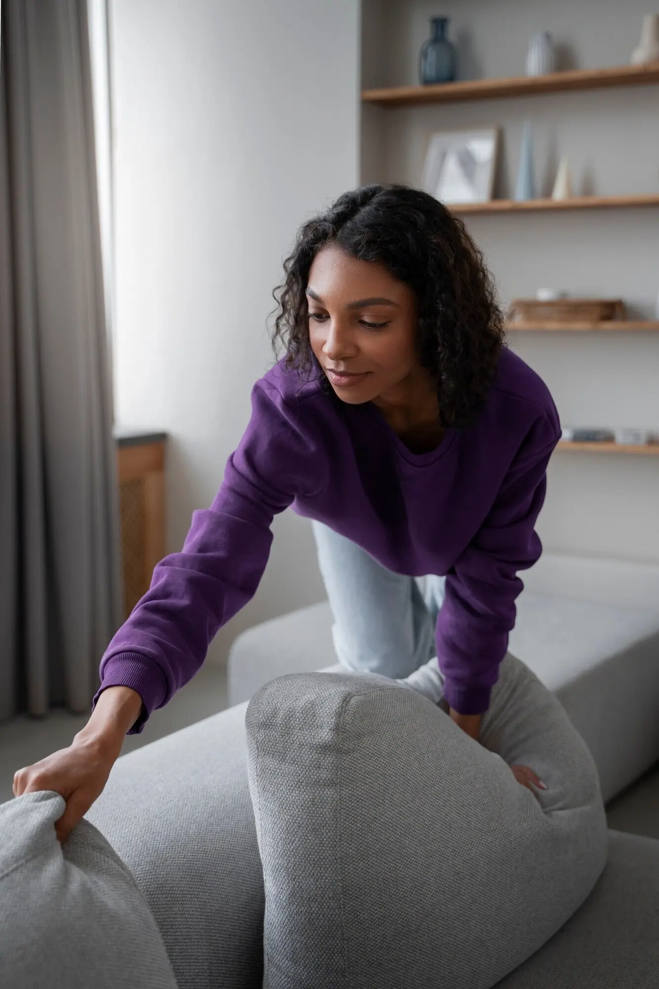 An interior designer is arranging pillows in a home.
